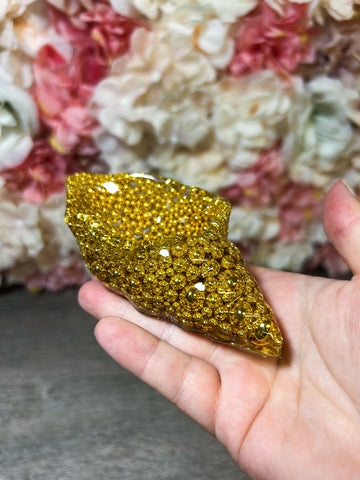 kleine Muschelschale mit goldenen Perlen